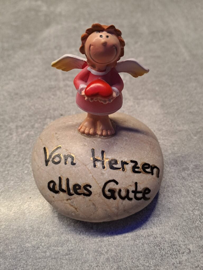 Von Herzen alles Gute - pinker Schutzengel auf hellbeigem Stein