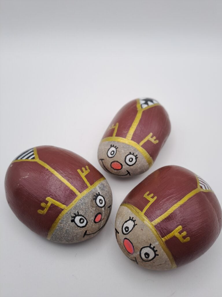 Drei als Maikäfer bemalte Steine