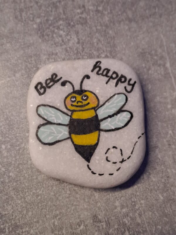 Glücksstein „Bee happy“ mit Biene für die Hosentasche, weißer Stein mit aufgemaltem Bienchen und der Aufschrift Bee happy und "Bee" mit Doppel-e geschrieben wegen dem englischen Wort bee für Biene