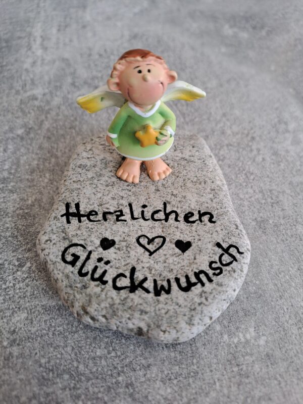 Hellgrauer Stein mit Spruch "Herzlichen Glückwunsch" grüner Schutzengel ist darauf geklebt