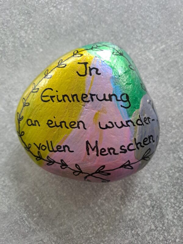 In Erinnerung an einen wundervollen Menschen Gedenkstein in bunten Metallicfarben mit diesem Spruch als Aufschrift und einer kleinen Blätterbordüre in schwarz außen herum