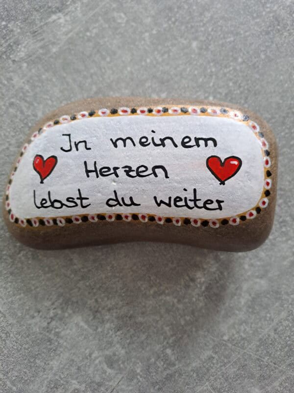 In meinem Herzen lebst du weiter Spruch Stein auf grauen Stein geschrieben mit weißem Hintergrund und mehrfarbiger Bordüre außen herum