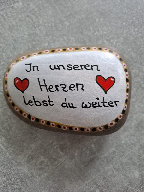In unseren Herzen lebst du weiter Gedenkstein mit weißem Hintergrund und bunter Bordüre sowie zwei roten Herzen