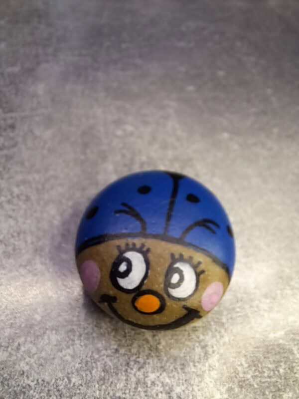 Stein bemalt als Blauer Glückskäfer Berti mit fröhlichem Gesicht