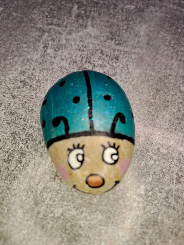 ganz heller Stein, bemalt als Kleiner türkiser Glückskäfer Tommy