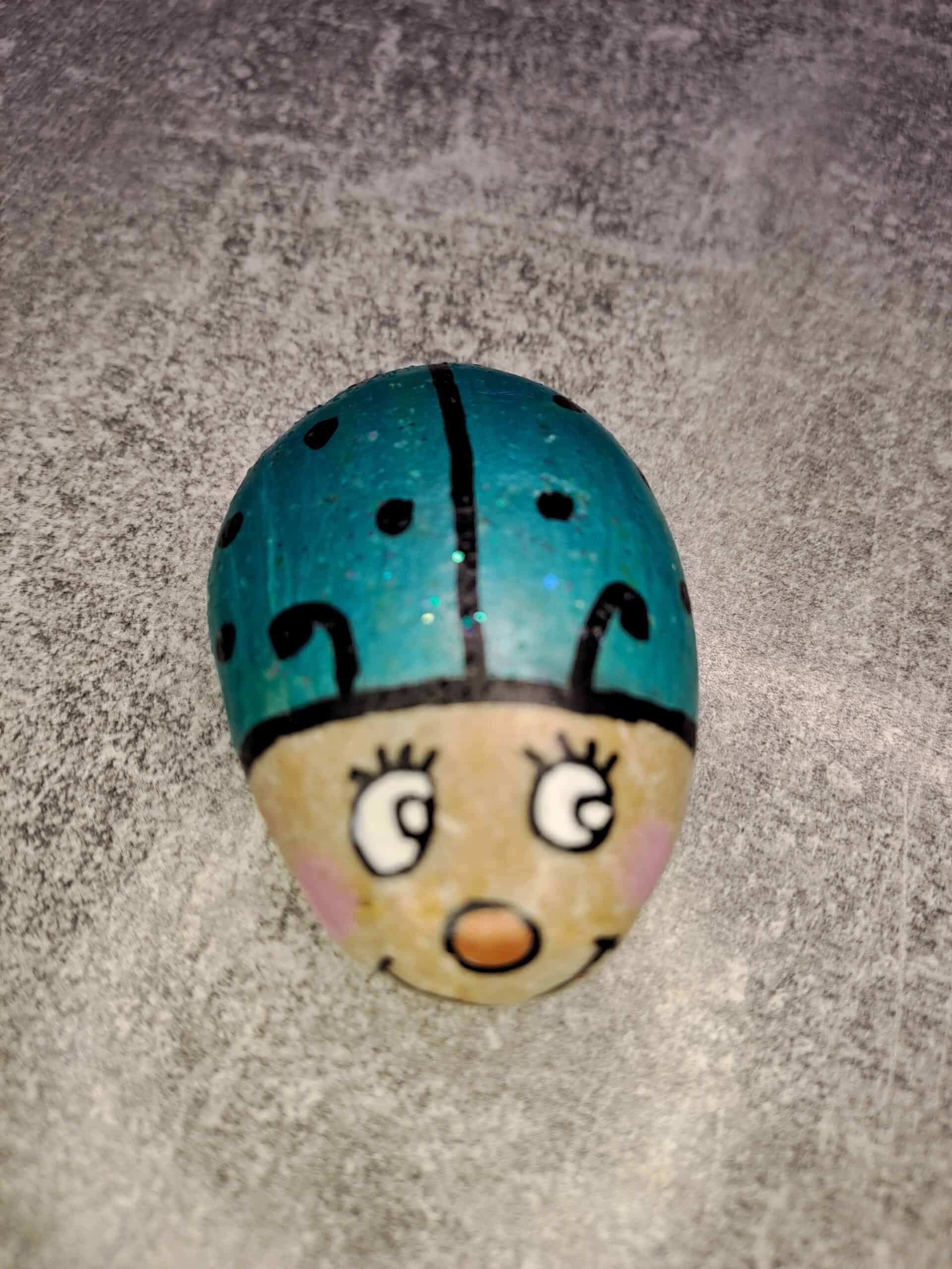 ganz heller Stein, bemalt als Kleiner türkiser Glückskäfer Tommy