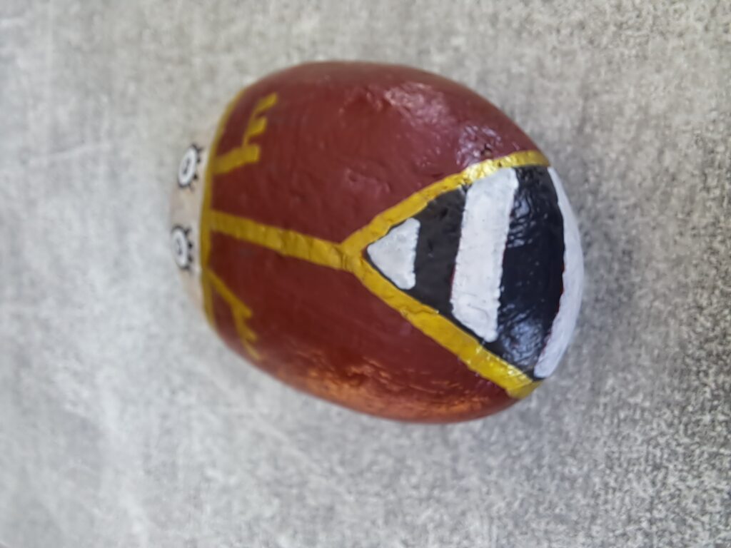 Maikäfer auf Stein malen, dieses Mal mit ganz breiten weißen Linien in dem schwarzen Bereich