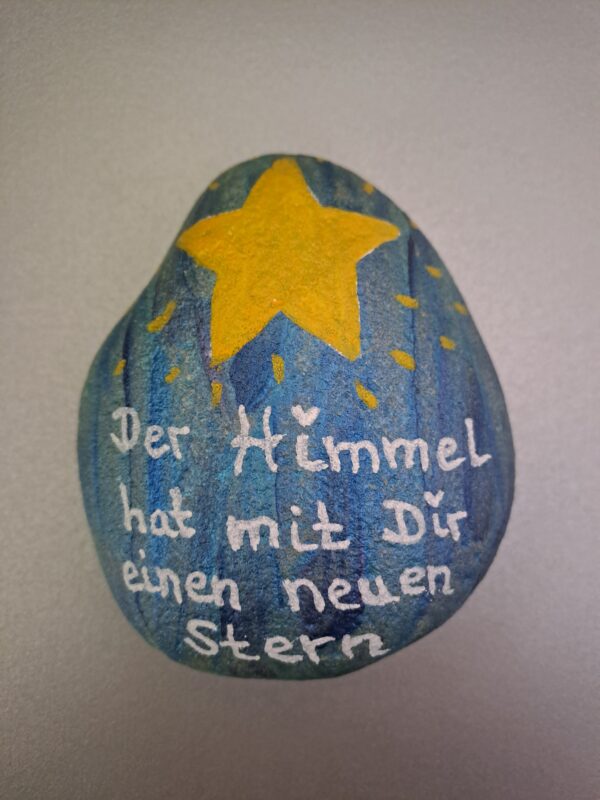 Neuer Stern Gedenkstein, blau-metallic-marmorierter Stein mit gelbem Stern und der Aufschrift "Der Himmel hat mit dir einen neuen Stern."