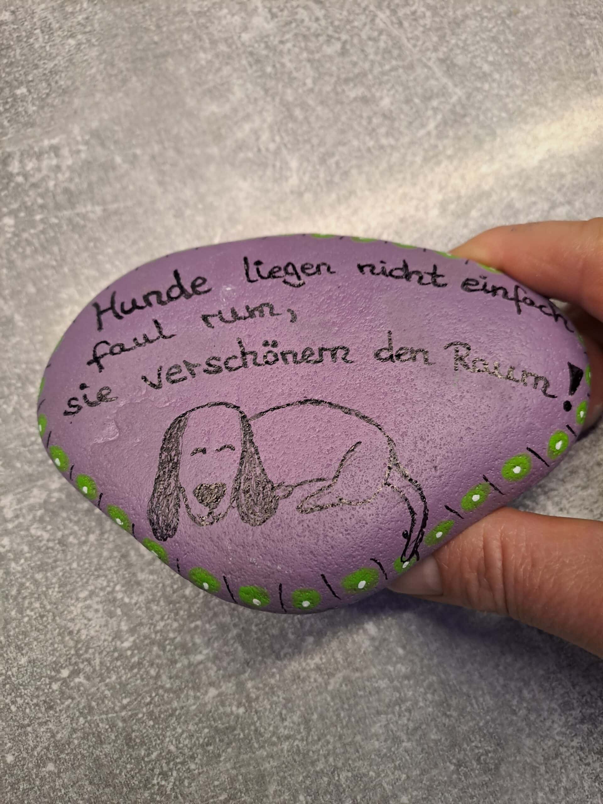 Hunde liegen nicht faul rum Spruch-Stein, weiteres Foto des lila Steines, damit man auch die untere Bordüre unter dem aufgemalten Hund sieht