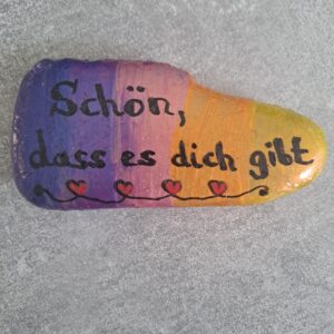 Spruch Stein mit der Aufschrift Schön, dass es dich gibt, in den Farben lila, pink, orange und gelb bemalt