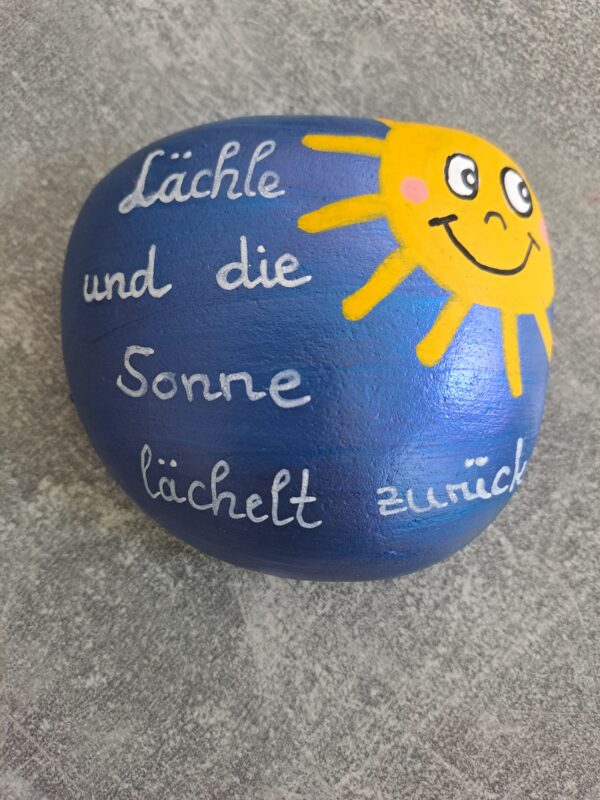 Sonnenstrahlen Spruchstein mit dem Text Lächle und die Sonne lächelt zurück