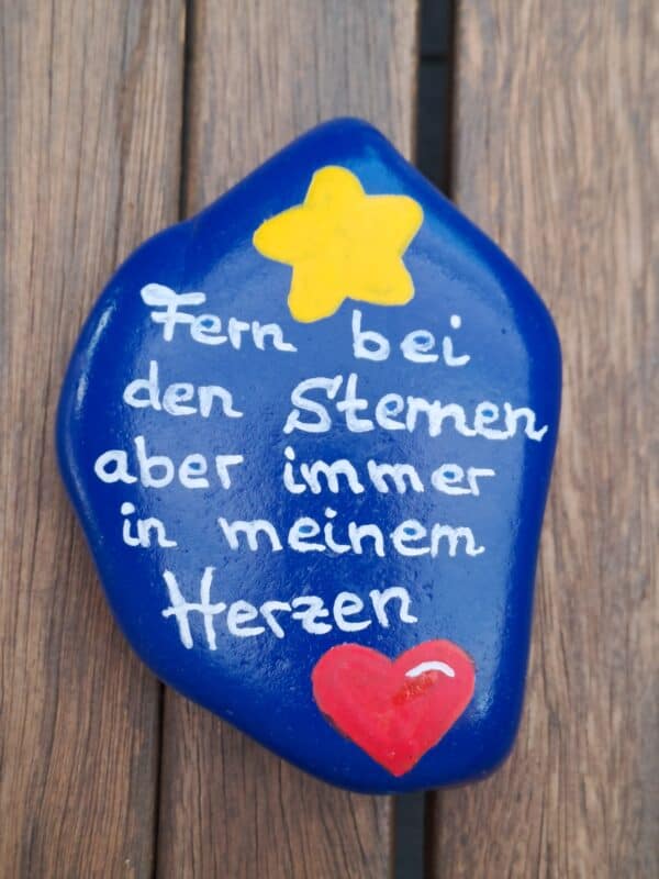 Dunkelblauer Gedenkstein mit der Aufschrift "Fern bei den Sternen aber immer in meinem Herzen", dazu ein gelber Stern und ein rotes Herz